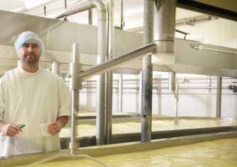Man next to cheese being made
